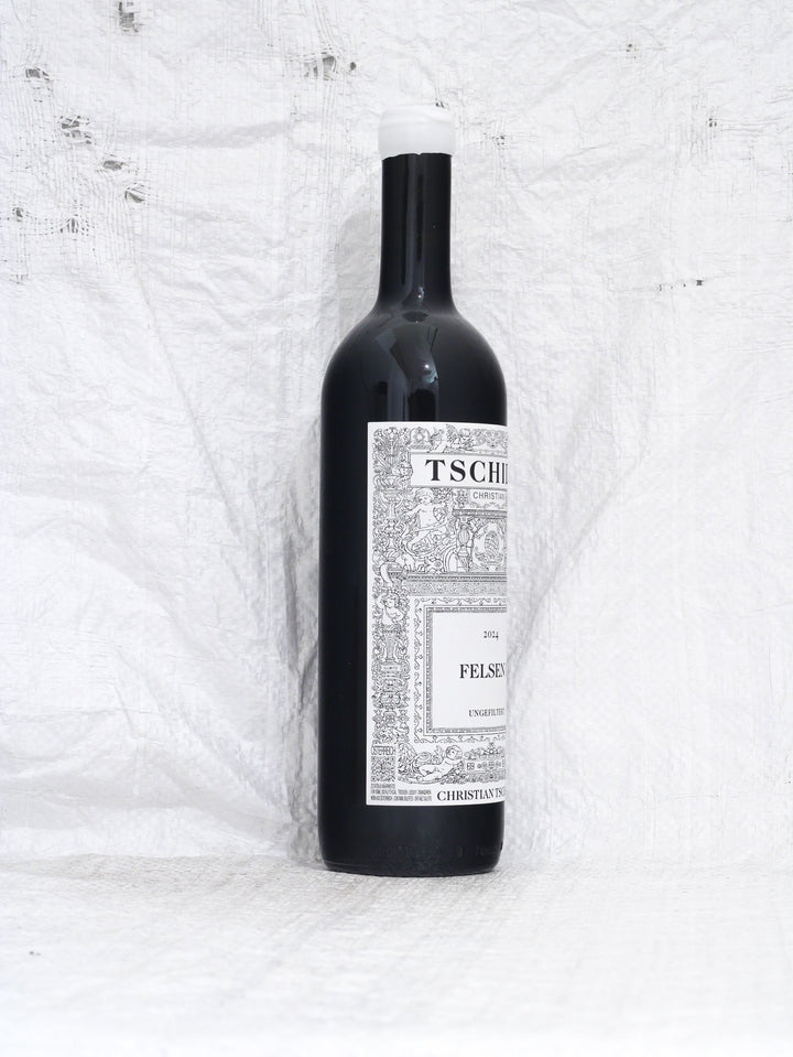 Seitenansicht Flasche Christian Tschida Felsen I 2024, ein puristischer Syrah aus dem Burgenland. Minimal Intervention Naturwein mit dem charakteristischen künstlerischen Etikett.