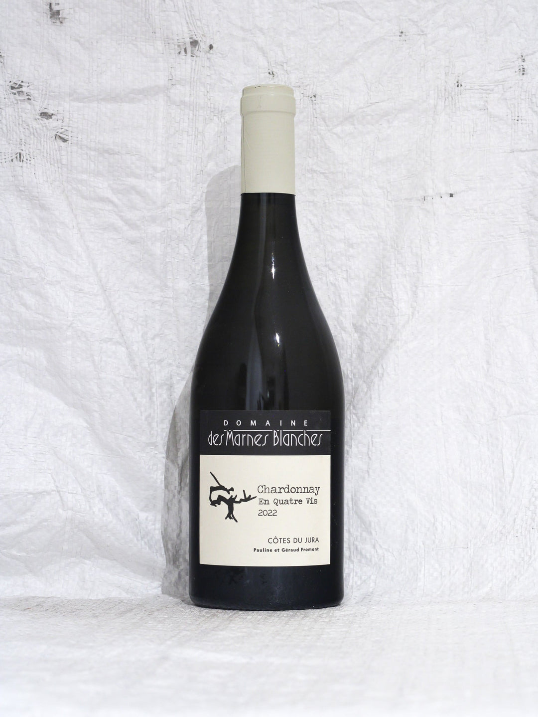 Vorderansicht der Flasche Chardonnay En Quatre Vis 2022 von Domaine des Marnes Blanches, ein trockener Biowein aus dem Jura (Frankreich) mit Fokus auf Mineralität.