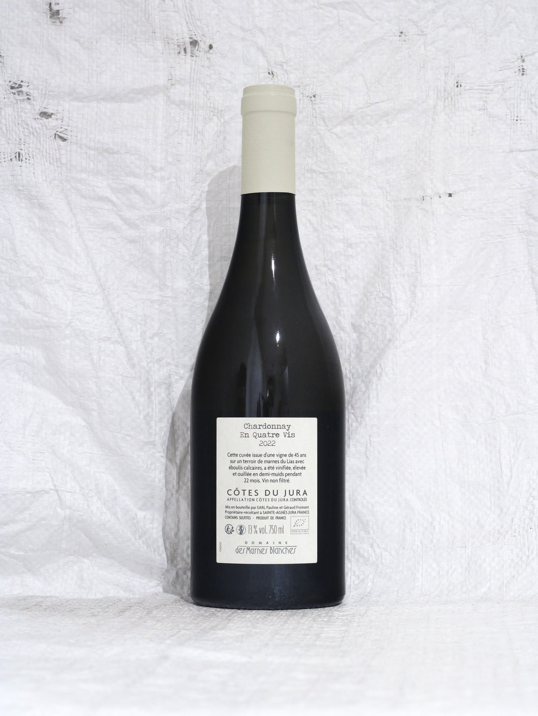 Rücketikett des Chardonnay En Quatre Vis 2022, Domaine des Marnes Blanches. Enthält Details zur Herkunft Côtes du Jura, Bio-Zertifizierung und Abfüllung durch Pauline und Géraud Fromont.